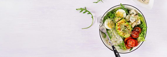 healthy-green-vegetarian-buddha-bowl-lunch-with-eggs-rice-tomato-avocado-and-blue-cheese-on-table un prânz sănătos