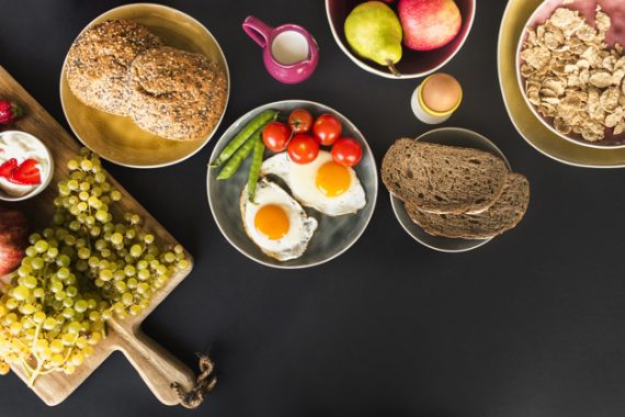 fruits-muesli-fruits-and-fried-omelette-with-tomatoes-and-peas-on-black-background_23-2147863003